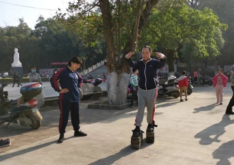 Pé de ferro: Por que um Chinês resolveu andar por aí com um peso total de 150kg? iron shoes walking2 750x529 1 | Bizarro | bizarro, china, chinês, estranho, ferro, sapatos