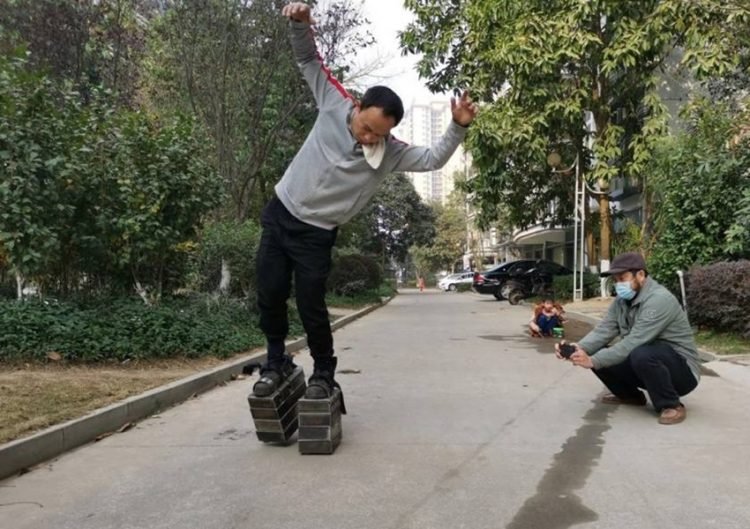 Pé de ferro: Por que um Chinês resolveu andar por aí com um peso total de 150kg? iron shoes walking3 750x529 1 | Bizarro | bizarro, china, chinês, estranho, ferro, sapatos