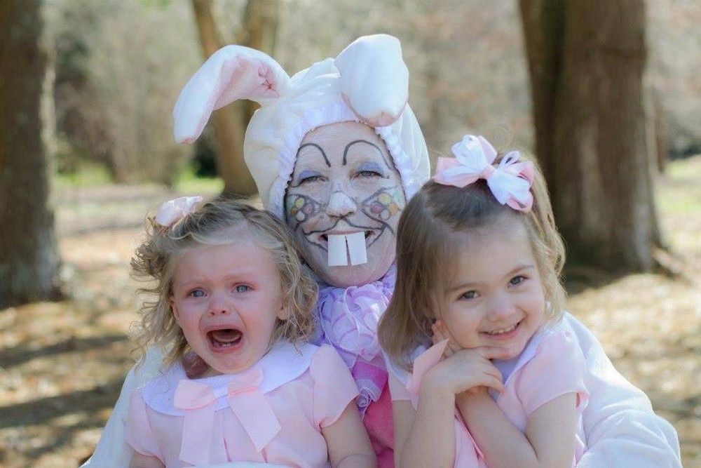 Foto gump do dia: Páscoa traumática Menina pequena com vestido de renda branco segurando um coelho vivo com expressão de terror