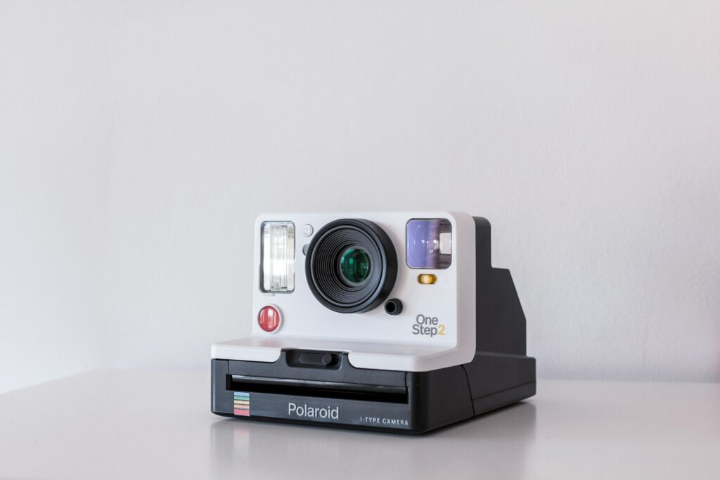 Foto gump do dia: A conquista da Polaroid white and black Polaroid One Step 2 instant camera on white board